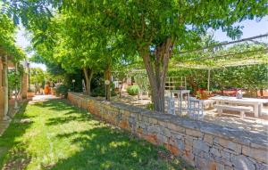 Un muro de contención de piedra con una mesa y un árbol. en Casal Del Borgo 6, en Ostuni