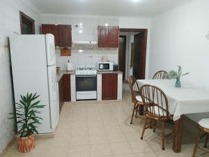 a kitchen with a table and a white refrigerator at La Ñata in Tandil