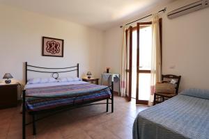 una camera da letto con un letto, un tavolo e una finestra di Bed and breakfast Le Camelie ad Alghero