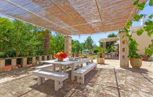 a picnic table with benches under a pergola at Casal Del Borgo 3 in Ostuni