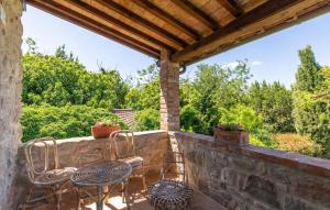 eine Terrasse mit Stühlen und Tischen auf einer Steinmauer in der Unterkunft Pet Friendly Home In Cortona With Wifi in Cortona