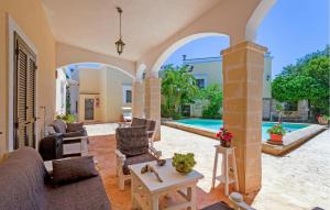 sala de estar con sofá, sillas y piscina en Casal Del Borgo 7, en Ostuni