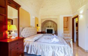 Un dormitorio con una cama blanca con una cómoda y una chimenea. en Casal Del Borgo 7, en Ostuni