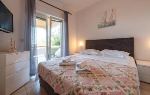 a bedroom with a bed with towels on it at 2 Bedroom Lovely Apartment In Mandre in Mandre