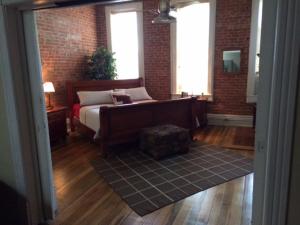 a bedroom with a bed and a brick wall at The 1857 in Paducah