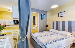 ein kleines Schlafzimmer mit einem Bett und einer Küche in der Unterkunft Amazing Apartment In La Rochelle With Wifi in La Rochelle