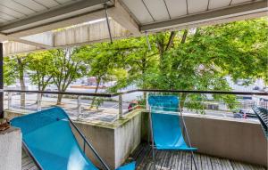 2 blaue Stühle auf einem Balkon mit Straßenblick in der Unterkunft Amazing Apartment In La Rochelle With Wifi in La Rochelle + 11 Fotos