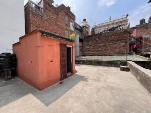 a brick building with a gate in a courtyard at Room in Traditional Nepali house in Kathmandu