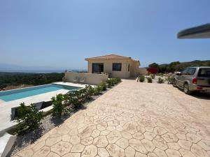 a house with a car parked in front of a driveway at Villa Sunrise in Chrisokellaria
