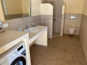 a bathroom with a sink and a washing machine at Villa Sunrise in Chrisokellaria +27 photos