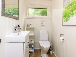 a small bathroom with a toilet and a sink at 6 person holiday home in Løkken in Løkken