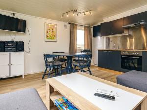 a kitchen and living room with a table and chairs at 6 person holiday home in Løkken in Løkken