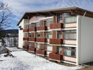 a building with red balconies on it in the snow at Schluchseestube 3309 in Schluchsee