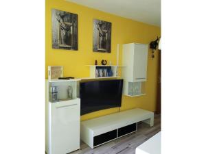 a living room with a tv and a yellow wall at Schluchseestube 3309 in Schluchsee