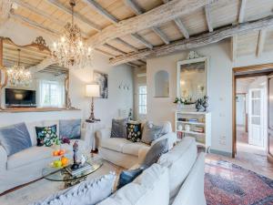 a living room with white furniture and a chandelier at Tuscan Farmhouse with Infinity Pool Retreat in Matraia