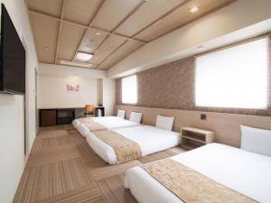 a row of four beds in a hotel room at Vessel Hotel Hiroshima Peace Blvd in Hiroshima +71 photos