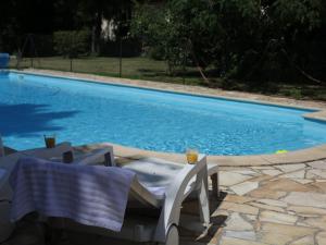 una piscina con due sedie e un tavolo accanto ad essa di Quend-Plage Apartment with Pool, cleaning included a Quend-Plage