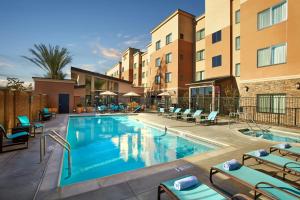 a pool at a hotel with chairs and a hotel at Residence Inn by Marriott Los Angeles Redondo Beach in Redondo Beach