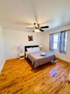 a bedroom with a bed and a ceiling fan at Charming & Cozy Family Home Near Plaza, Movie hall in Cornwall