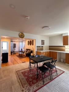 a kitchen and living room with a table and chairs at Charming & Cozy Family Home Near Plaza, Movie hall in Cornwall