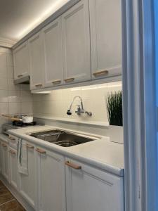a kitchen with white cabinets and a sink at Sinsa Station North Europe Art gallery in Seoul