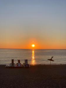a boat on the beach with the sunset in the background at Mekad in Oued Laou