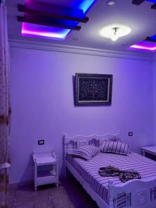a bedroom with a bed with purple lights on it at 1 Sweet & Spacious House in Hammamet tunisia in Hammamet