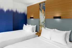two beds in a hotel room with white pillows at Aloft New York Brooklyn in Brooklyn +50 photos