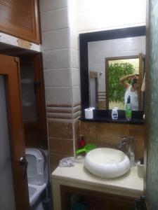 a man taking a picture of a bathroom mirror at Appartement aissa in Oulad Akkou