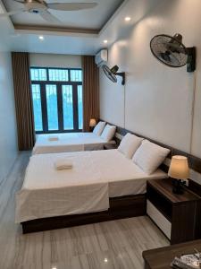 twee bedden in een kamer met twee ramen bij HoTel Ven Hồ in Thái Thụy