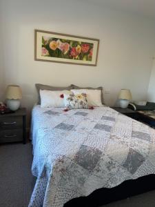 um quarto com uma colcha numa cama com dois candeeiros em Bellbird Hideaway em Pleasant Valley