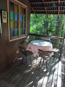 a patio with a table and chairs on a deck at Casinha da Mata in Chapada dos Guimarães