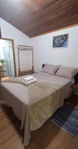 a bedroom with a large bed with two towels on it at Casinha da Mata in Chapada dos Guimarães