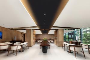 a dining room with tables and chairs and windows at Atour Hotel Xiamen Guanyinshan East Huandao in Xiamen