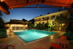 a swimming pool in front of a building at night at Perdikia Beach in Oludeniz