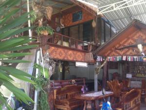 uma sala com mesa e cadeiras e uma varanda em The Lazy Bar Guest House em Praia de Ao Nang