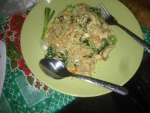 um prato amarelo de comida com um garfo e uma colher em The Lazy Bar Guest House em Praia de Ao Nang