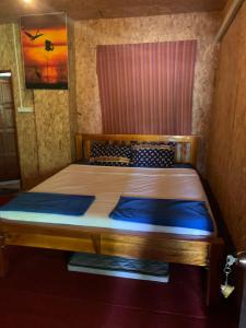um quarto com uma cama de madeira num quarto em The Lazy Bar Guest House em Praia de Ao Nang