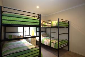 una habitación con tres literas en una casa en Boronia 6 30 Nettin Circuit, en Jindabyne