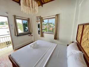 a bedroom with a large white bed with windows at Sun & Surf Hostel - STARLINK in Santa Monica