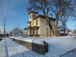 una casa amarilla en una calle cubierta de nieve en The Pepin Mansion B&B on Mansion Row - 10 min to start of the Bourbon Trail, en New Albany