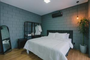a bedroom with a white bed and a blue wall at Blockhaus in Rancho Queimado