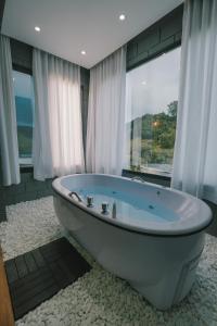 a bath tub in a bathroom with a large window at Blockhaus in Rancho Queimado +38 photos