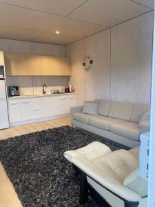 a living room with a couch and a kitchen at Point Wells Holiday Apartment in Big Omaha