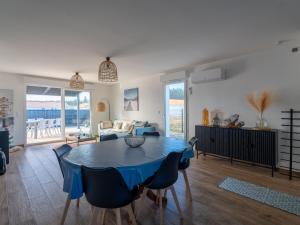 a living room with a blue table and chairs at Maison moderne à 6 km de Mimizan pour 6 personnes, ménage inclus - FR-1-50-156 in Saint-Paul-en-Born +6 photos