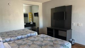 a hotel room with two beds and a flat screen tv at Motel 6 Modesto, CA in Modesto +81 photos