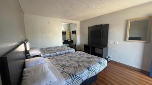 a hotel room with two beds and a tv at Motel 6 Modesto, CA in Modesto