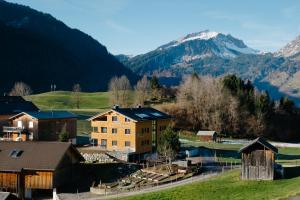 une maison dans un village avec des montagnes en arrière-plan dans l'établissement Kanis Appartements, à Schoppernau