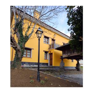 una luz de la calle frente a un edificio amarillo en Apartamento La Casa del Abuelo Justo, en Miñagón