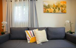 a gray couch with two pillows sitting in a living room at La Cabane Sereine - Pause Nordique & simplicite in Rouyn-Noranda